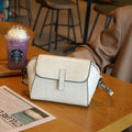Brown women's shell-shaped genuine leather messenger bag with a single cross-body strap and visible stitching.