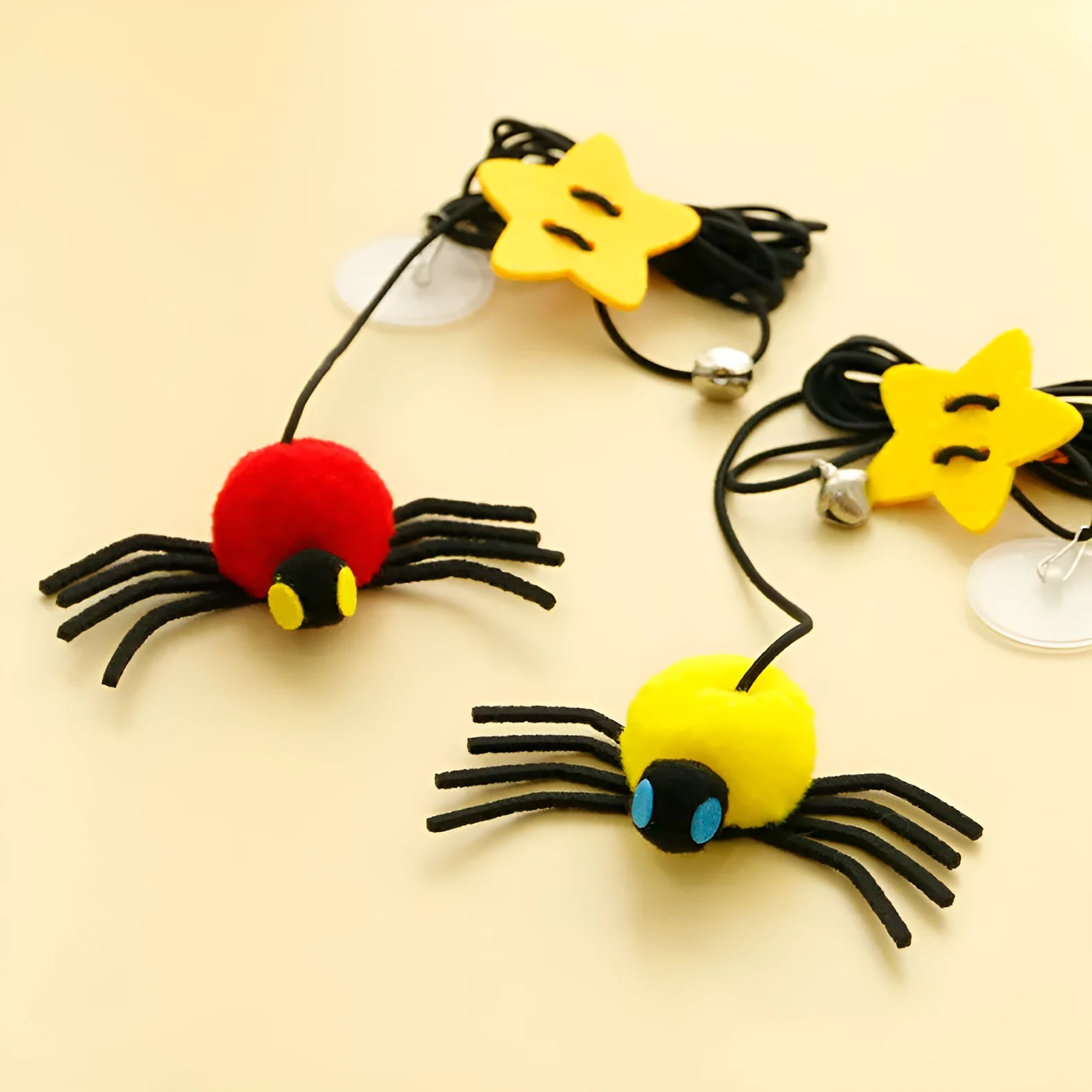 Red and yellow hanging door cat toy with elastic rope, feather, bell, and spider attachments.